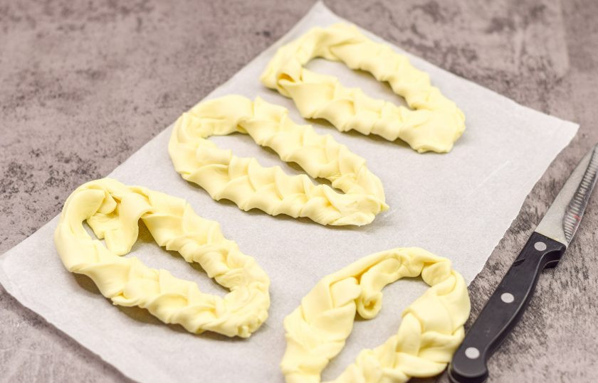 1. Этап. Плетеные Хот-доги из слоеного теста с плавленым сыром: Выверните две косички и соедините их между собой.