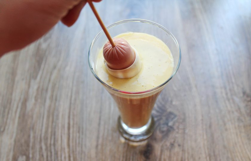 1. Этап. Сосиски в панировке с сыром: Вылейте тесто в узкий, высокий стакан и опустите сосиску полностью в него. Выньте и дайте немного стечь лишнему тесту.