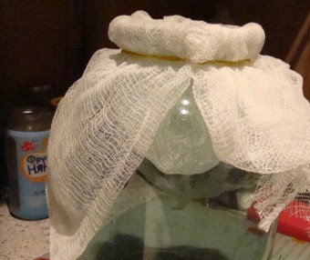 1. Этап. Наливка из клюквы: Через месяц можно продолжить приготовление. Одеваем на горлышко банки сложенную вдвое марлю и процеживаем через нее наливку.