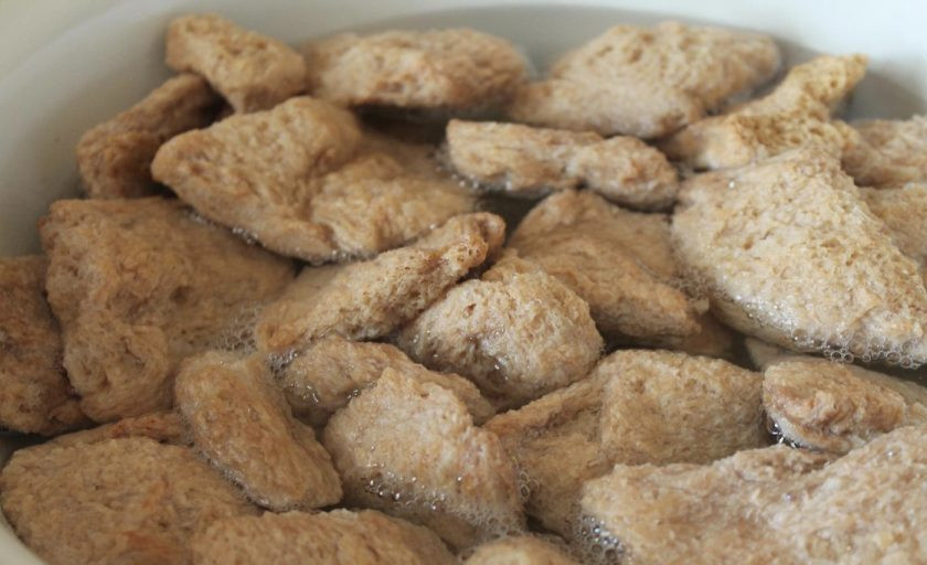 1. Этап. Соевый шницель: Берем глубоку емкость. В нее наливаем воду. По температуре она должна быть средней: между теплой и горячей. Кладем в эту же емкость сухие соевые шницели. Они должны быть распределены в воде равномерно. Пусть полежат так с часок.