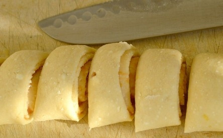 1. Этап. Творожные улитки: Скручиваем рулет, нарезаем его на небольшие кусочки.