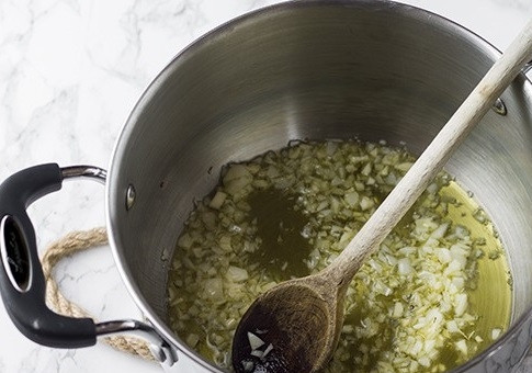 1. Этап. Рис с морепродуктами: В толстостенной кастрюле нагреваем 30 грамм сливочного и две столовых ложки оливкового масла. Добавим мелко нарезанную луковицу и зубчик чеснока. Обжариваем 2-3 минуты.