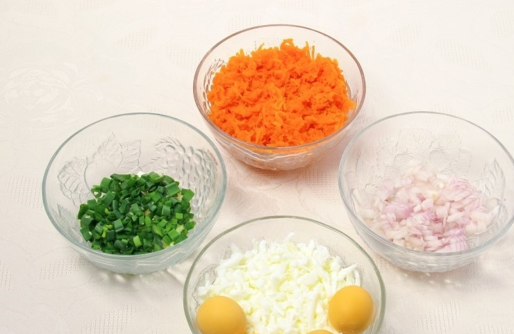 1. Этап. Салат Мимоза с рисом и сыром: 2. Отвариваю яйца и отделяю желтки от белков, последние измельчаю на крупной терке. Морковь отвариваю и остужаю, затем натираю на крупной терке. Репчатый и зеленый лук мою, затем измельчаю.