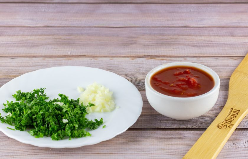 1. Этап. Горбуша в томатном соусе: Чеснок очистите, помойте и мелко порубите. Зелень также помойте и порубите. С помидоров снимите кожицу и разомните мякоть с соком.