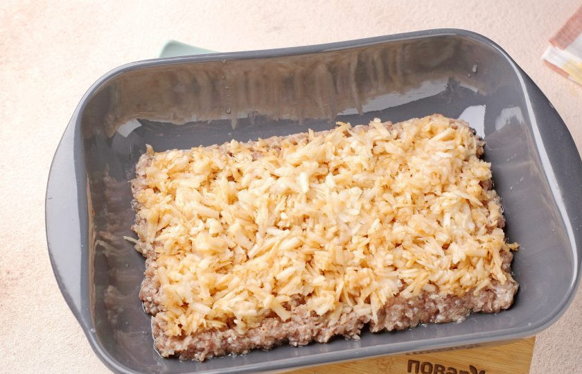 1. Этап. Запеканка из фарша с яблоками: Яблоки очистите от шкурки, натрите на крупной тёрке, слегка отожмите и выложите равномерно на фарш. Можно сбрызнуть яблоки лимонным соком.