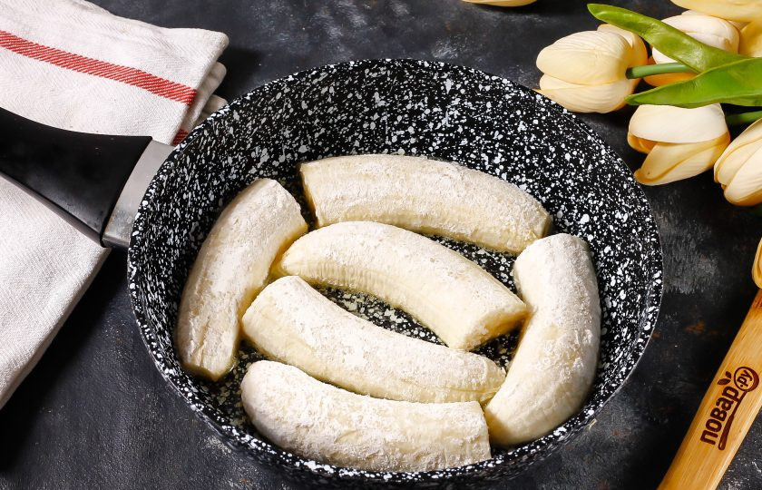 1. Этап. Жареные бананы в коньяке: Растопите в сковороде сливочное масло и выложите в него обпанированную банановую нарезку. Обжарьте примерно 2 минуты с одной стороны на умеренном нагреве до карамелизации, низ должен слегка подрумяниться.