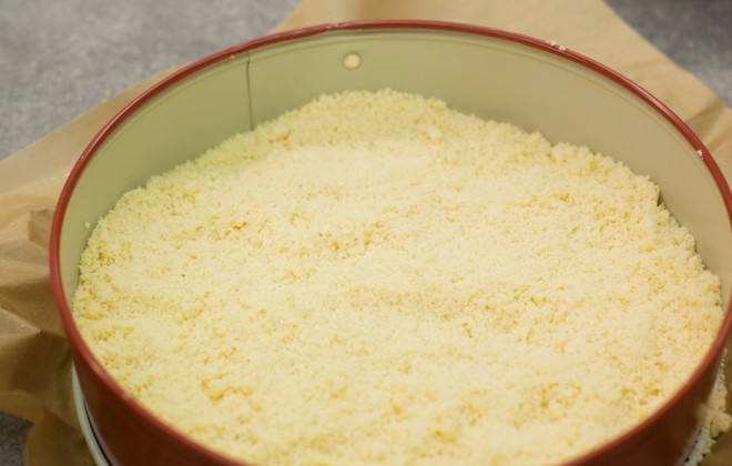 1. Этап. Ватрушка на скорую руку: Берем форму для выпечки, смазываем ее маслом и посыпаем сухарями или мукой. Выкладываем масляно-мучную крошку.