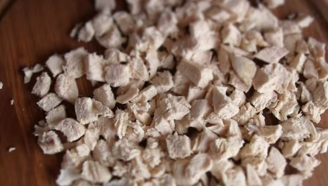 1. Этап. Салат Дамский с ананасом: 1. Отварите до готовности куриную грудку, остудите и нарежьте небольшими кубиками.