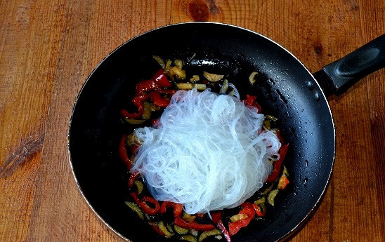 1. Этап. Салат с фунчозой и баклажанами: Выложите в сковороду предварительно обсушенную фунчозу.