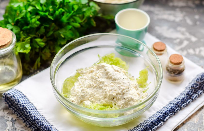 1. Этап. Кабачковые оладьи без масла: Всыпьте в миску пшеничную муку, добавьте соль и молотый перец по вкусу.