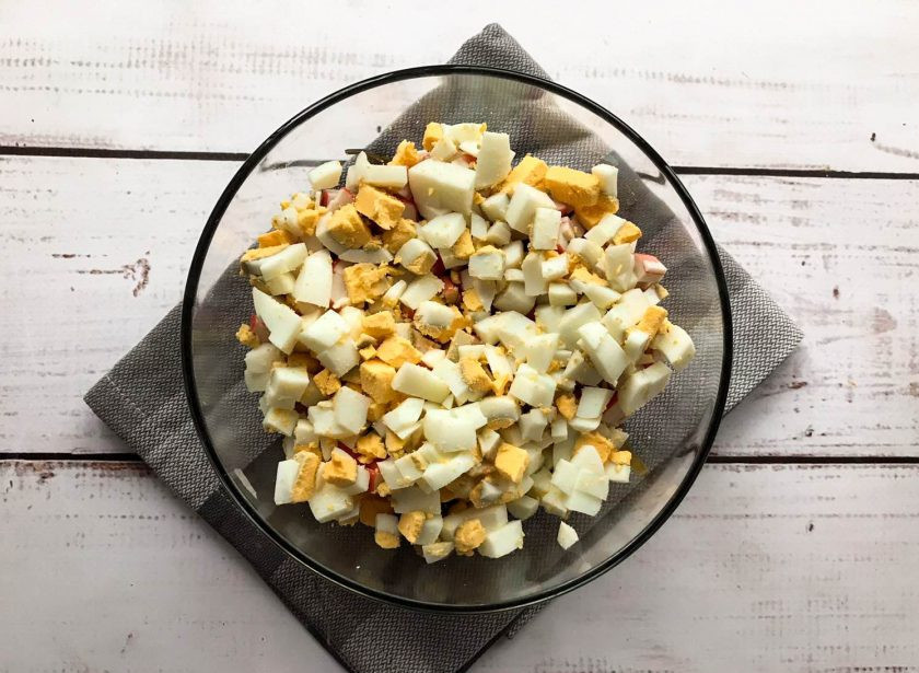 1. Этап. Салат с морской капустой и шпротами: Яйца очистите от скорлупы, нарежьте небольшими кусочками и высыпьте в тарелку.