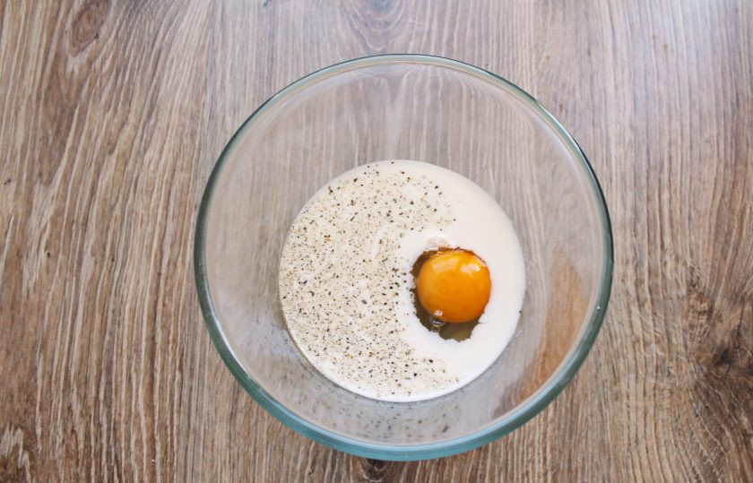 1. Этап. Сосиски в панировке с сыром: В сковороду налейте растительное масло и поставьте на средний огонь разогреваться. В миску налейте молоко, добавьте яйцо, соль и поперчите. Все перемешайте до однородности.