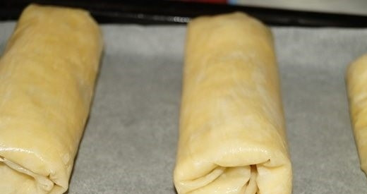 1. Этап. Рулетики из теста фило с крабово-сырной начинкой: 6. Выложите рулеты на противень, застеленный пергаментом. Смажьте растопленным сливочным маслом и отправьте в разогретую до 190 градусов духовку.