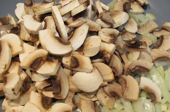 1. Этап. Пенне с грибами: Расколите на сковороде оливковое масло, выложите грибы, рубленный чеснок и лук. Обжаривайте всё вместе 8-10 минут.