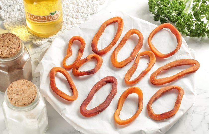 1. Этап. Вяленый кальмар: После чего выложите кольца кальмара на противень и разогрейте духовку до 60-70 градусов. Поместите противень в духовку и подсушите кольца примерно 2 часа, оставив дверцу техники приоткрытой. После чего остудите кольца 2 часа и снова подсушите 2 часа. После остывания у вас должны получиться плотные кольца, которые будут пружинить при нажатии.