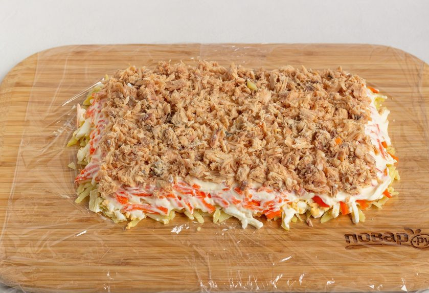 1. Этап. Салат-рулет Мимоза на Новый год 2025: Горбушу очистите от костей и кожи, разомните вилочкой. Выложите четвертым слоем и сверху немного майонеза.