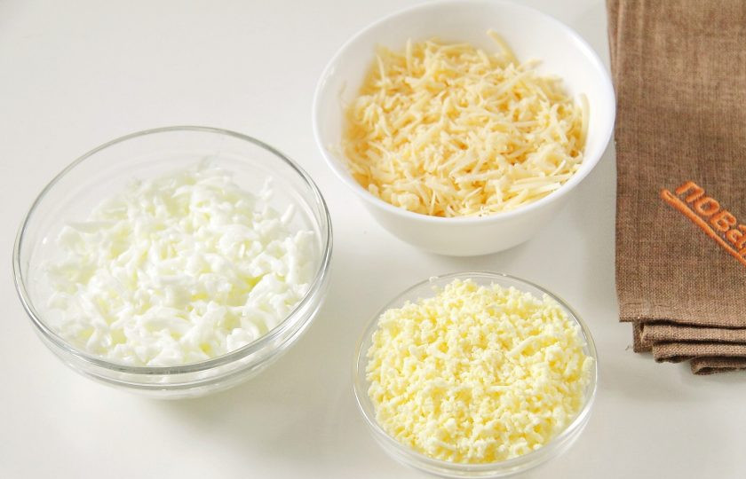 1. Этап. Новогодние рулетики из крабовых палочек: Отделите белки от желтков. Натрите белки на крупной терке, желтки отдельно на мелкой. Сыр также натрите на мелкой терке.