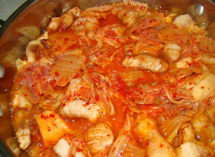 1. Этап. Кимчи со свининой: 3. Накройте крышкой, потушите несколько минут, всыпьте приготовленный лук. Продолжайте тушить до того момента, как лук поменяет цвет. Перемешайте продукты.