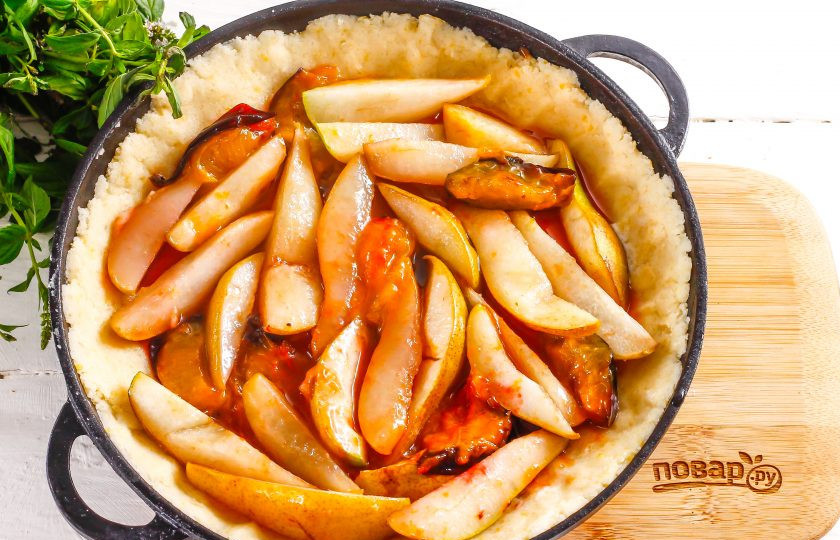 1. Этап. Песочный пирог с грушами и сливами: В середину формы на тесто выложите карамелизированную фруктовую нарезку и аккуратно распределите ее. Поместите форму в духовку на 25-30 минут.