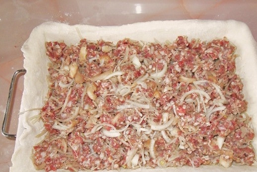 1. Этап. Пирог с мясом из слоеного дрожжевого теста: Сверху на картошку выложите фарш. Для этого смешайте мясо с (порезанным кольцами или полукольцами) луком и грибами. Не увлекайтесь шампиньонами, так как при термической обработке они выделяют слишком много жидкости.