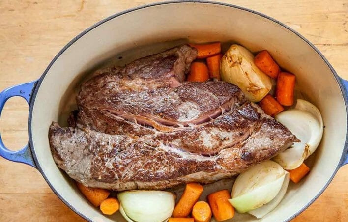 1. Этап. Говядина по-мароккански: 2. Разогрейте кастрюлю с оливковым маслом, выложите мясо и обжаривайте его со всех сторон до золотистой корочки. Выложите вокруг мяса лук и морковь.