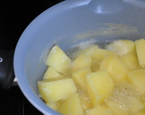 1. Этап. Картофельные гнезда с фаршем: Картошку очистите от кожуры и нарежьте кубиками, чтобы она быстрее приготовилась. Промойте водичкой, положите в кастрюлю. Залейте чистой водой и поставьте на огонь. Варите до полной готовности, немного подсолив воду.