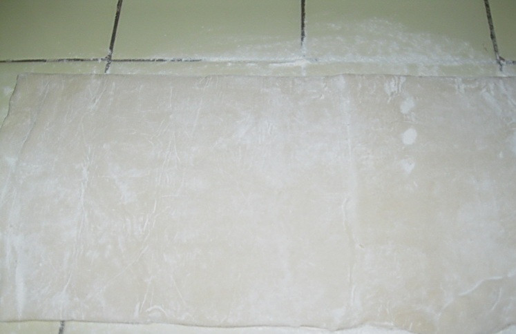 1. Этап. Слоеные пирожки с творогом: 3. В основу добавьте также сахар, в том числе ванильный. Раскатайте пласт теста и нарежьте его на небольшие прямоугольники толщиной около 3 мм.