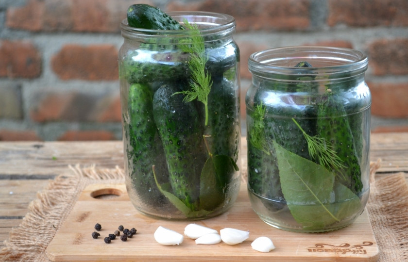 1. Этап. Огурцы на зиму без закатки: На дно простерилизованных банок выложите листья вишни и укроп. Затем плотненько выстройте огурцы стоя, чтобы максимально наполнить банку.