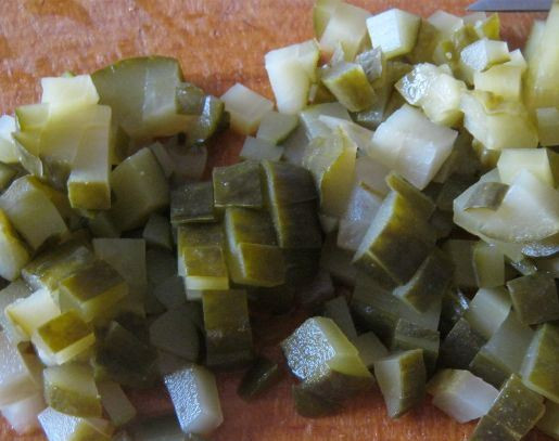 1. Этап. Салат Оливье с крабовыми палочками: Теперь мелко нарезаем маринованные огурцы.