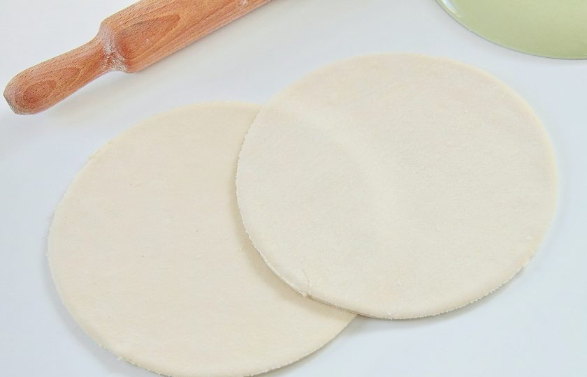 1. Этап. Слоеный шоколадный пирог: 4. Как правило в упаковке идет два пласта теста. Каждый необходимо раскатать на присыпанной мукой поверхности и приложив любую подходящую по размеру тарелку, вырезать при помощи ножа круги, обрезав углы.