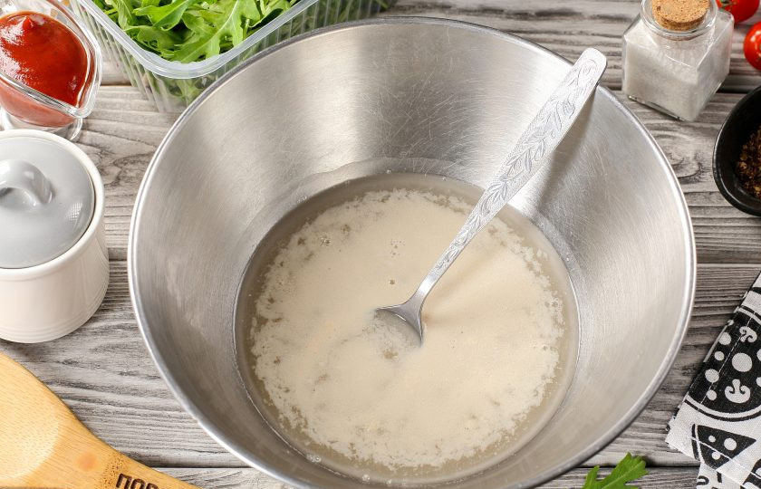 1. Этап. Пицца с рыбой: Соедините тёплую воду, сахар и дрожжи. Перемешайте и оставьте на 10-15 минут до появления пенной «шапочки».