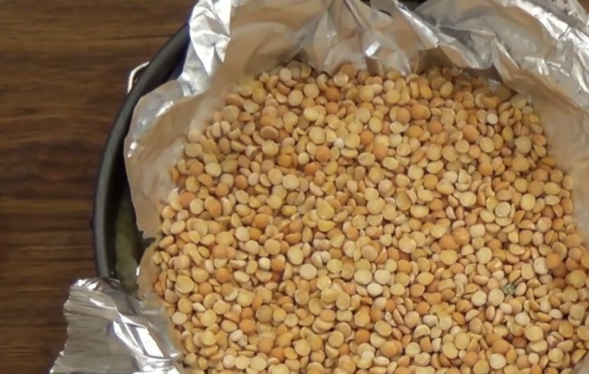 1. Этап. Пирог из тыквы по-английски: 3. Затем застелите тесто фольгой и насыпьте в нее груз (горох или фасоль). Выпекайте основу пирога в разогретой до 200 градусов духовке 15 минут.