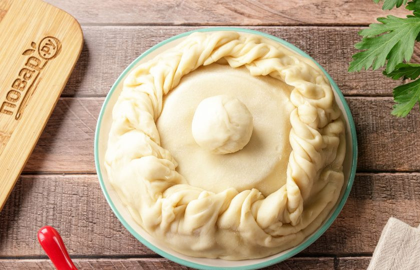 1. Этап. Жаркое в горшочке из теста: Аккуратно (перевернув миску) вытащите тесто с начинкой из формы и ещё раз защипните края по бокам. Можете защипнуть как я косичкой или любым другим удобным способом. Из оставшегося кусочка теста скатайте маленький шарик, это будет ручка горшочка.