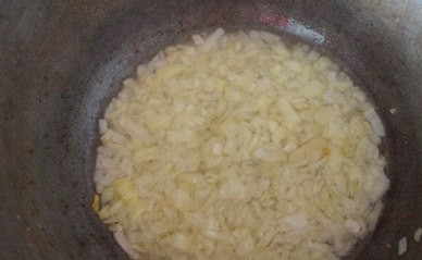 1. Этап. Тушеная капуста с колбасками: Разогреваем в глубокой сковороде или в казане растительное масло. Добавляем очищенный и мелко нарезанный лук. Обжариваем до легкого золотистого цвета.