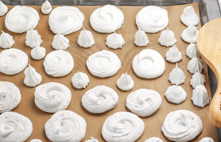 1. Этап. Меренга с шоколадом: Выложите приготовленную белковую массу в кондитерский шприц или пакет и отсадите на специальный коврик для выпекания или на пергаментную бумагу, застеленную на противень. Отправьте меренги в духовку на 1,5 часа. Если у вас техника без конвекции, то слегка приоткройте дверцу духовки, чтобы меренги не стали коричневыми в процессе сушки.