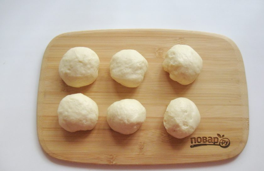 1. Этап. Пирожки с конфетами: Достаньте тесто из миски, обомните и разделите на шарики весом 50-60 грамм.