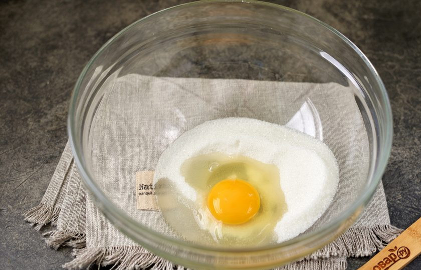 1. Этап. Тертый пирог с вареньем на маргарине: Первым делом вбейте в глубокую миску крупное куриное яйцо, всыпьте сахар и взбейте венчиком минуты 3-4, пока масса не побелеет.