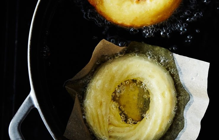 1. Этап. Пончики из заварного теста: 6. Очень хорошо разогрейте достаточное количество масла. Аккуратно опустите тесто вместе с бумагой.