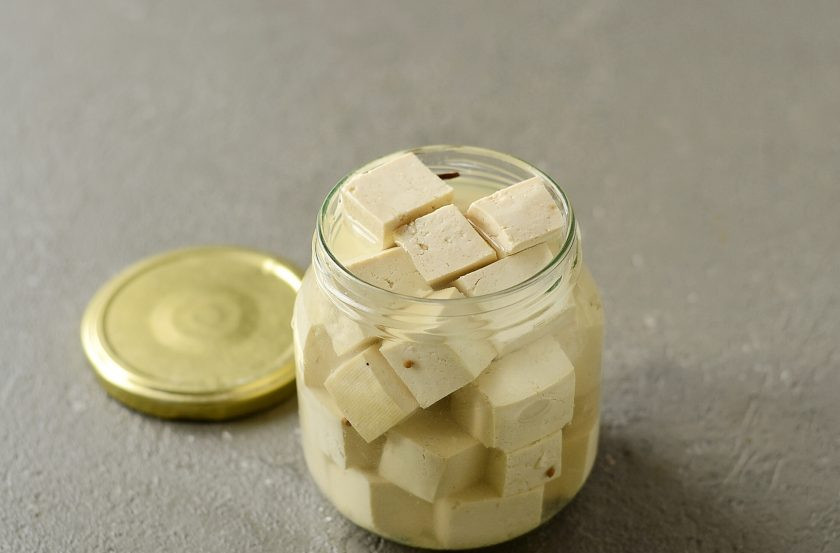 1. Этап. Постные хачапури: Тофу нарежьте кубиками. В банку выложите лавровый лист, гвоздику, семена кориандра и перец горошком. Добавьте тофу. Для маринада растворите в горячей воде сахар и соль. Влейте горячий маринад и уксус в банку. Оставьте мариноваться минимум на 8 часов.