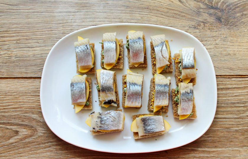 1. Этап. Канапе с селедкой и черным хлебом на шпажках: Филе селедки порежьте на кусочки по количеству хлеба, у меня получилось 12 штук. Выложите селедку поверх яблока.