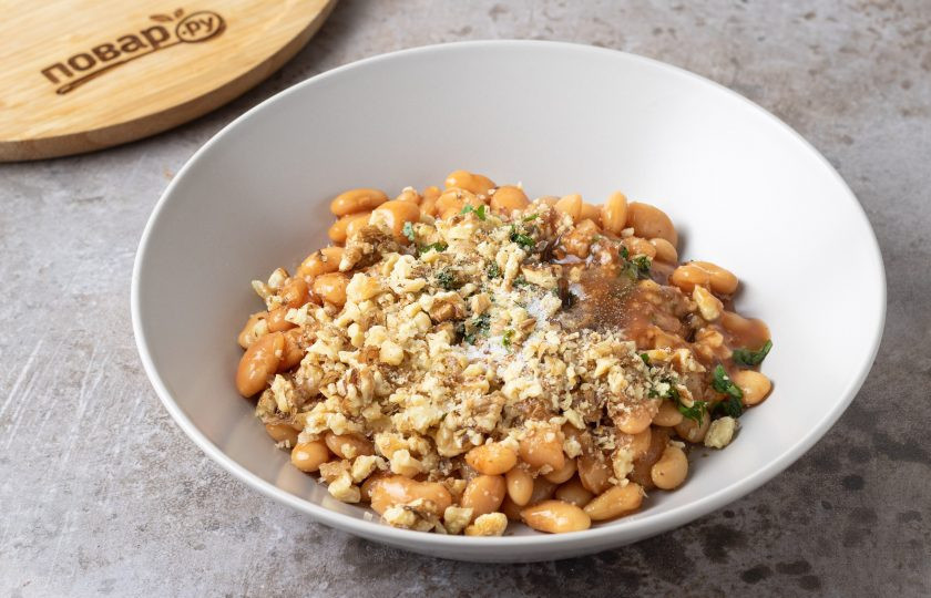 1. Этап. Салат с фасолью в томатном соусе: Заправьте салат 1-2 ст.л. томатного соуса от фасоли, добавьте грецкие орехи. Посолите и поперчите по вкусу. Перемешайте.