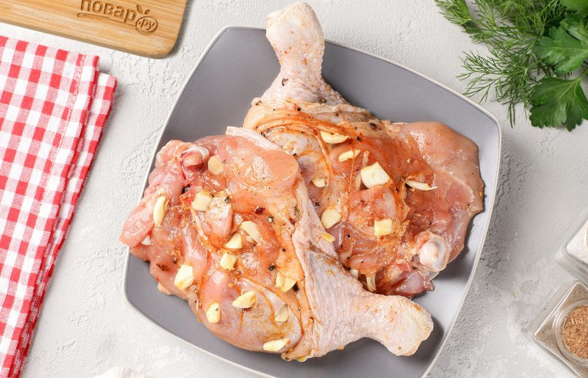 1. Этап. Куриные ножки со сметаной и сыром: Натрите мясо солью и специями. Затем сделайте надрезы ножом и вставьте туда нарезанный пластинами чеснок.