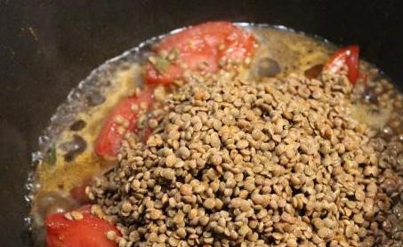 1. Этап. Тушеная чечевица: В сковороде или в казане подогрейте масло. Крупно нарежьте овощи, отправьте их на огонь. Спустя 5 минут всыпьте чечевицу и добавьте пряности.