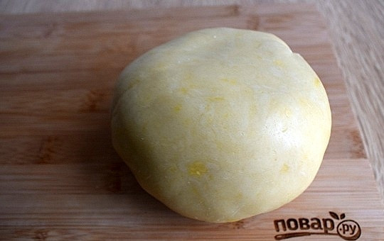 1. Этап. Печенье Весенние листья: Просейте в миску муку, сахарную пудру и ванилин. Добавьте желток и сливочное масло, порезанное на кусочки. Замесите мягкое тесто, не липнущее к рукам. Заверните его в пищевую пленку и положите в холодильник на 15 минут.