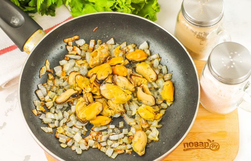 1. Этап. Рис с мидиями в сливочном соусе: Половину репчатого лука нарежьте мелким кубиком. Прогрейте растительное масло и обжарьте в нем луковую нарезку до румяности. Добавьте мидии в масле. Можно использовать и замороженные мидии, предварительно их очистив. Обжарьте примерно 1-2 минуты.