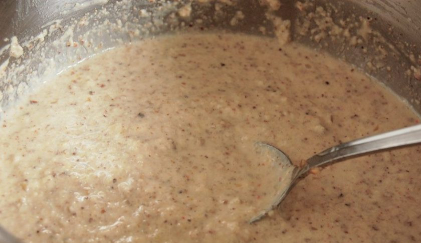 1. Этап. Сациви с курицей по-грузински: Влейте в ореховую массу бульон порциями, чтобы получилась консистенция жидкой сметаны. Поставьте соус на огонь, доведите его до кипения. Постоянно мешайте. Затем влейте уксус уже без огня, а также соль и перец.