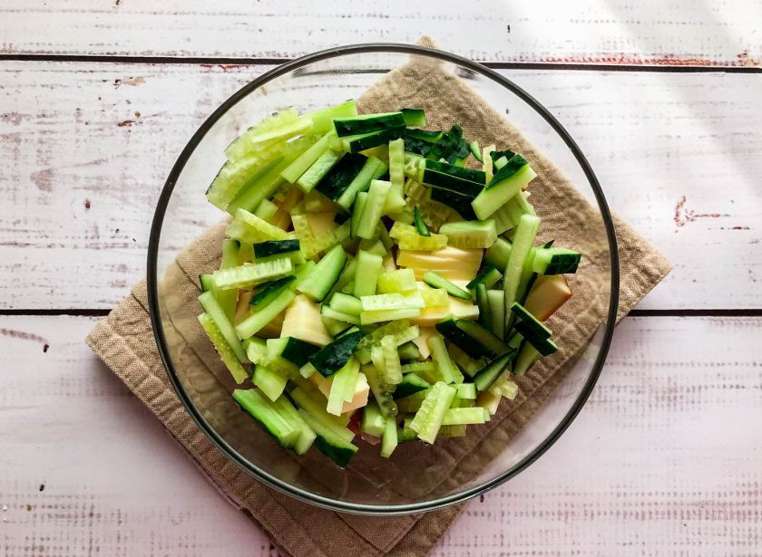 1. Этап. Салат София с копченым сыром: Огурцы хорошо помойте под проточной водой и мелко нарежьте.