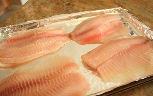 1. Этап. Запеченное филе тилапии в панировке: 1. Филе рыбки вымойте, хорошо обсушите бумажным полотенцем. Выложите на противень, застеленный фольгой или пергаментом. Посолите и поперчите по вкусу, можно добавить немного молотого чеснока или сбрызнуть соком лимона.