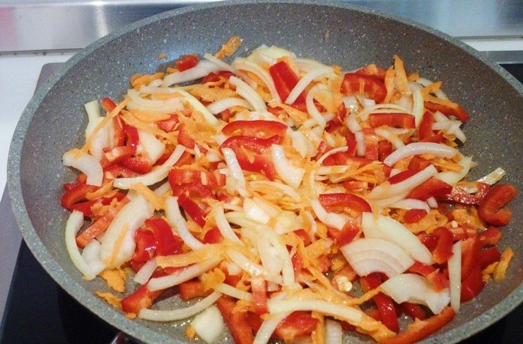 1. Этап. Фасоль по-мексикански: 2. Подготовьте овощи для поджарки. Очистите лук и нарежьте его соломкой. Очищенную морковь натрите на крупной терке. Болгарский красный перец освободите от плодоножки и семян, нарежьте соломкой. В разогретую с растительным маслом сковородку выложите овощи и обжарьте.