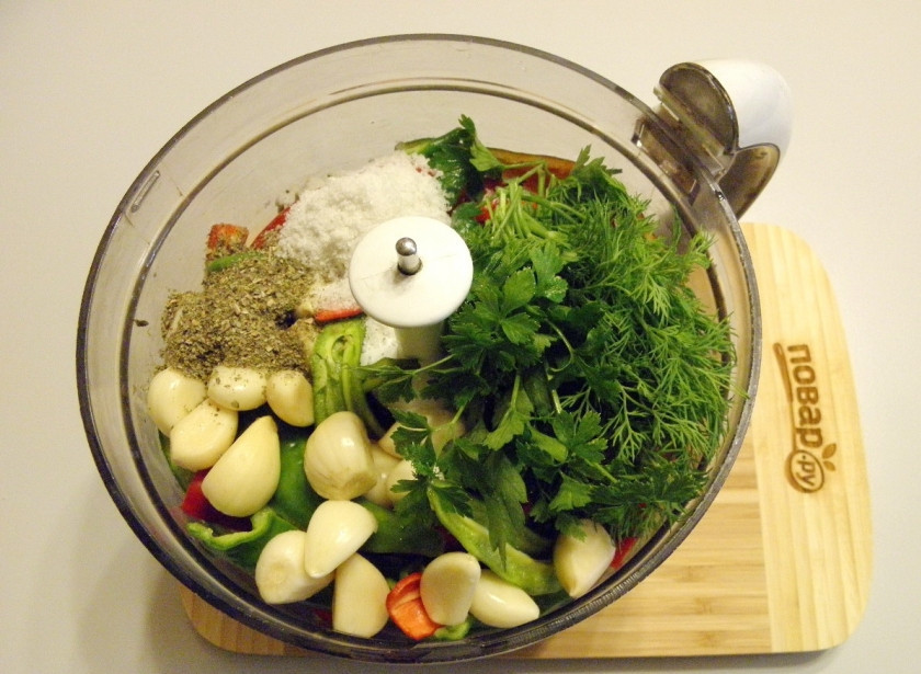 1. Этап. Аджика (классический рецепт): Добавьте в чашу измельчителя очищенный чеснок, вымытую зелень, сушеную зелень, соль.